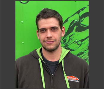 Man in black and green SERVPRO hoodie smiling