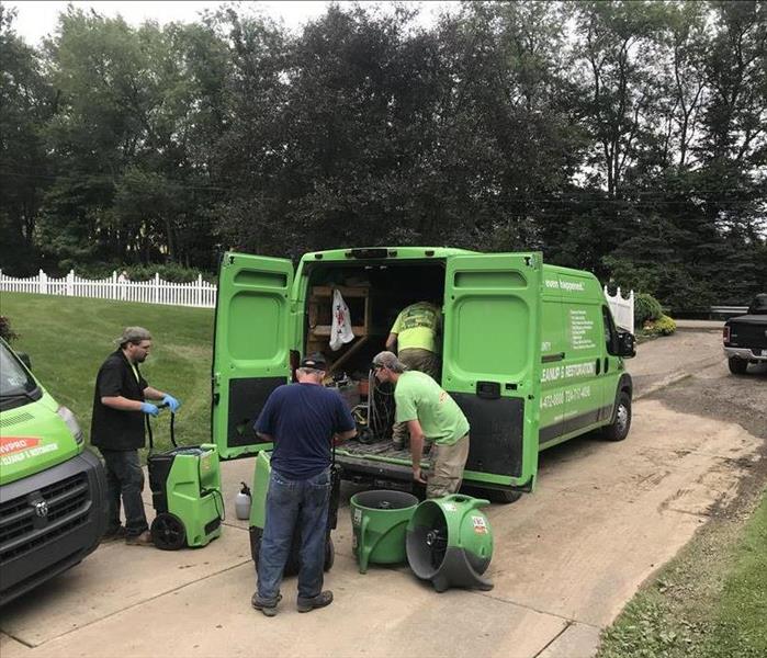 SERVPRO employees unloading drying equipment at a water damaged home