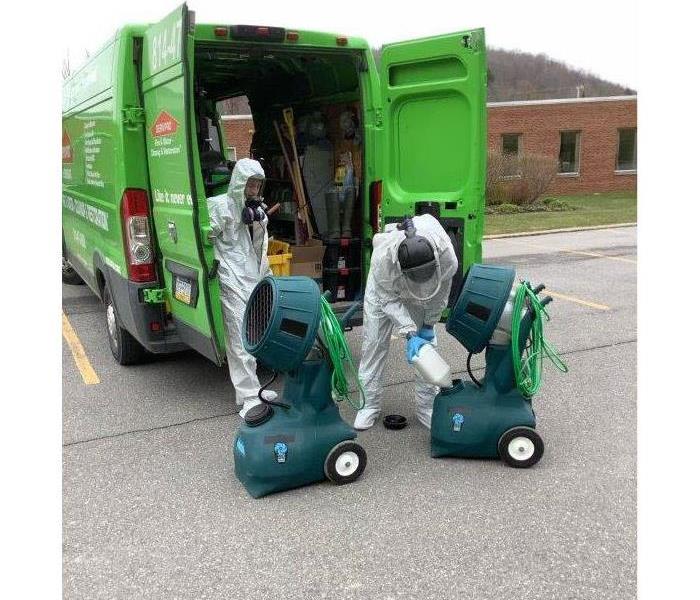two SERVPRO employees preparing to sanitize a commercial building